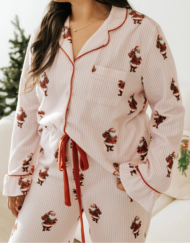 Model wearing pink-and-red striped Santa pajama set featuring button-up top and drawstring pants — cozy holiday lounge set available at TandyWear Boutique in Commack, NY.