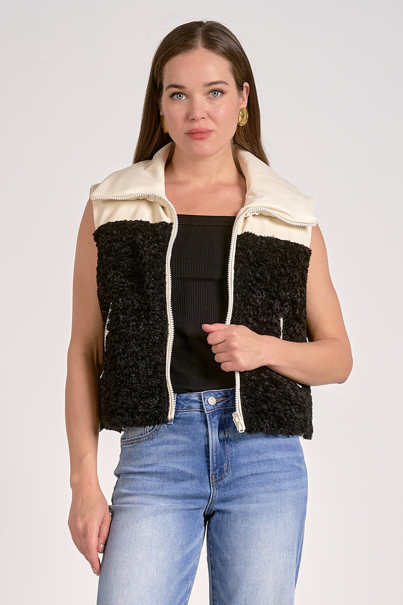 Reversible vest featuring a plush black texture on one side and a smooth cream fabric on the other, perfect for Long Island boutique fashion.