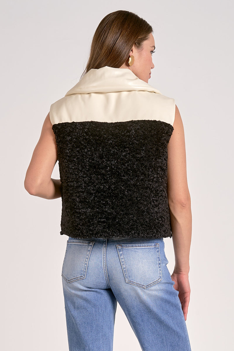 Reversible vest featuring a sleek black fluffy texture and cream front, perfect for adding stylish warmth in Long Island boutique fashion.