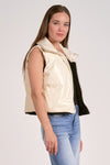 Reversible vest with a shiny cream exterior and soft black interior, offering a stylish fit perfect for Long Island boutique fashion.