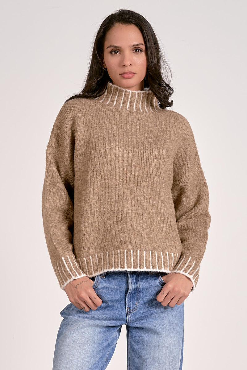Cozy Elan turtleneck sweater in warm beige with white ribbed stitching, perfect for effortless style at a Long Island women's boutique.
