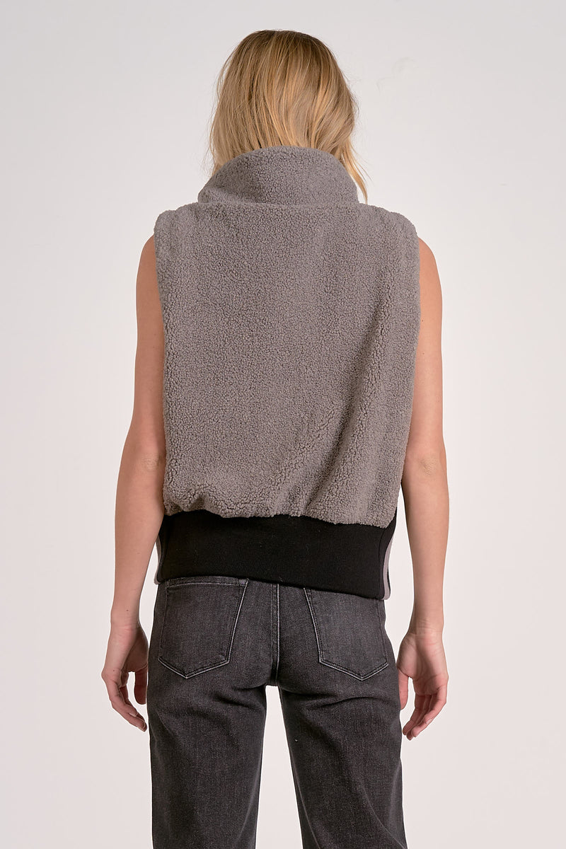 Cozy gray zip-up vest with a high collar and elastic hem, perfect for layering in Long Island boutique fashion.