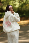 Cozy white puff hoodie featuring delicate pink floral patterns and "Happy Camp3r" logo, perfect for Long Island boutique fashion lovers.