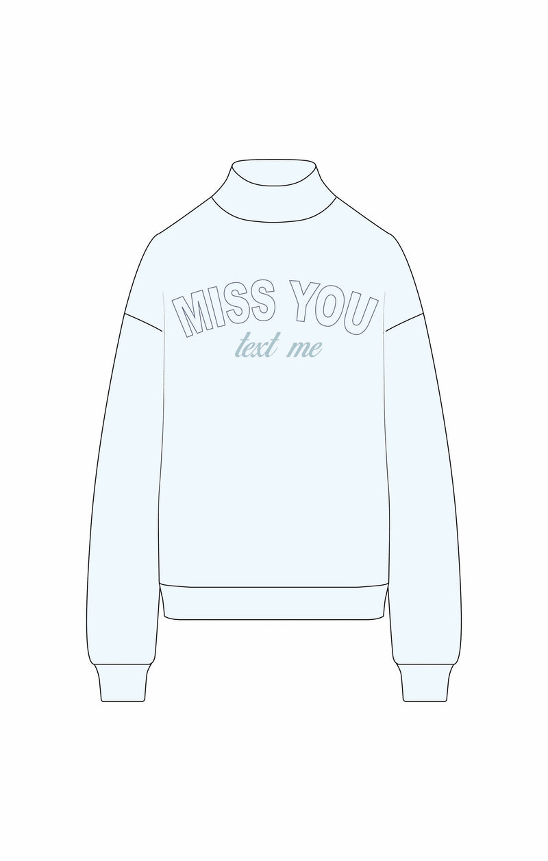 Soft blue mock neck sweatshirt featuring "MISS YOU text me" graphic, ideal for casual wear in Long Island boutique fashion.