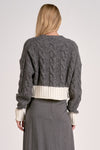 Cozy dual-tone sweater cardigan in gray with a ribbed white waistband and intricate cable knit design, perfect for Long Island boutique fashion.