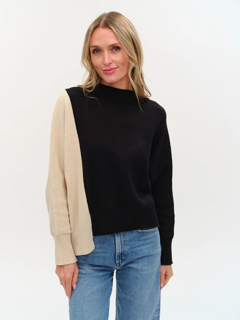 Colorblock uneven hem sweater featuring a stylish black and cream design, perfect for casual layering in Long Island boutique fashion.