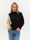 Colorblock uneven hem sweater featuring a cozy fit with black and cream panels, perfect for stylish layering in Long Island boutique fashion.