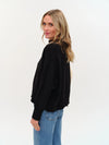 Soft black colorblock sweater with an uneven hem, featuring a relaxed fit and ribbed cuffs, perfect for Long Island boutique fashion.