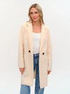 Elegant faux shearling long coat in soft cream with a tailored fit, featuring a double-button front and practical pockets, perfect for Long Island boutique fashion.