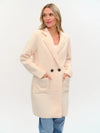 Light beige faux shearling long coat with a double-breasted front, side pockets, and a relaxed fit, ideal for Long Island boutique fashion.