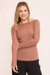 Soft, fitted long-sleeve top in a warm terracotta hue with subtle ribbing, perfect for layering in Long Island boutique fashion.